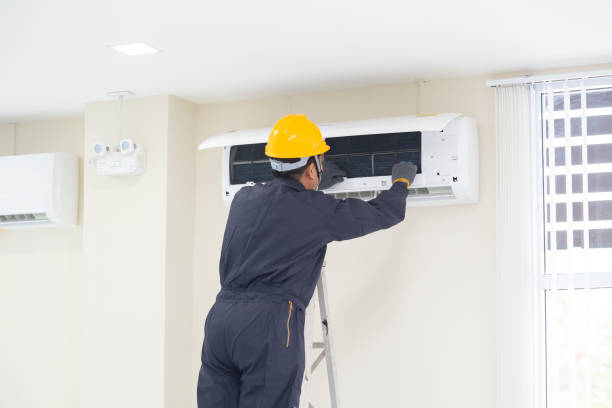 the mechanic technician are repairing air conditioner in room.