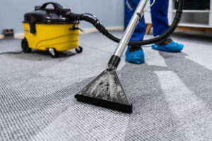 photo of janitor cleaning carpet with vacuum cleaner